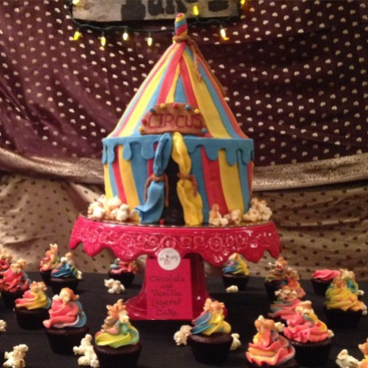 Circus themed women's center fundraiser party. chocolate and vanilla circus tent cake with chocolate and vanilla cupcakes with salted caramel popcorn on top.