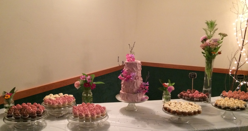 Strawberry Lemon wedding cake with strawberry cream cheese icing fresh sweet pea flowers and lavender and cupcakes