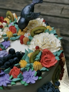 Hummingbird cake with buttercream flowers and fresh fruit